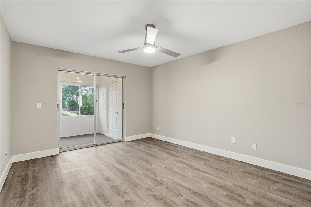 22375 Edgewater Drive, Unit 124 Punta Gorda, FL 33980 - Photo 11 of 29 wooden floor in an empty room with a window