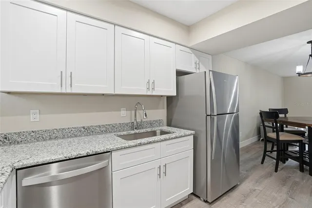 a kitchen with stainless steel appliances granite countertop a refrigerator sink and cabinets