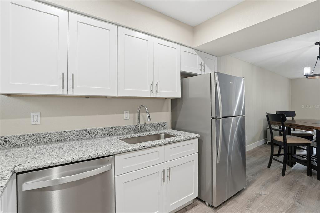 22375 Edgewater Drive, Unit 124 Punta Gorda, FL 33980 - Photo 5 of 29 a kitchen with stainless steel appliances granite countertop a refrigerator sink and cabinets