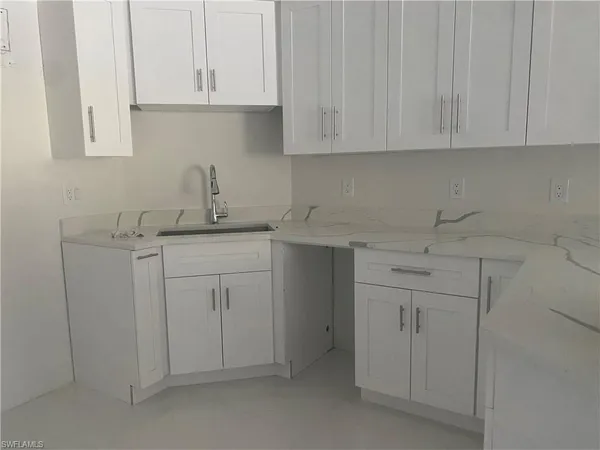 a kitchen with white cabinets and a sink
