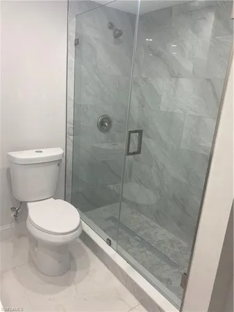 a bathroom with a toilet and a shower