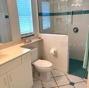 a bathroom with a granite countertop toilet and a sink