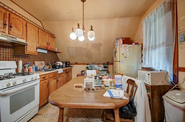 a kitchen with stainless steel appliances kitchen island granite countertop a sink a stove and refrigerator