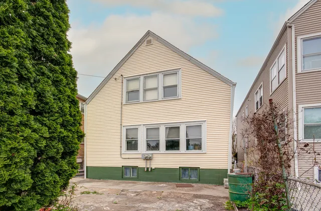 a front view of a house with a yard and potted plants