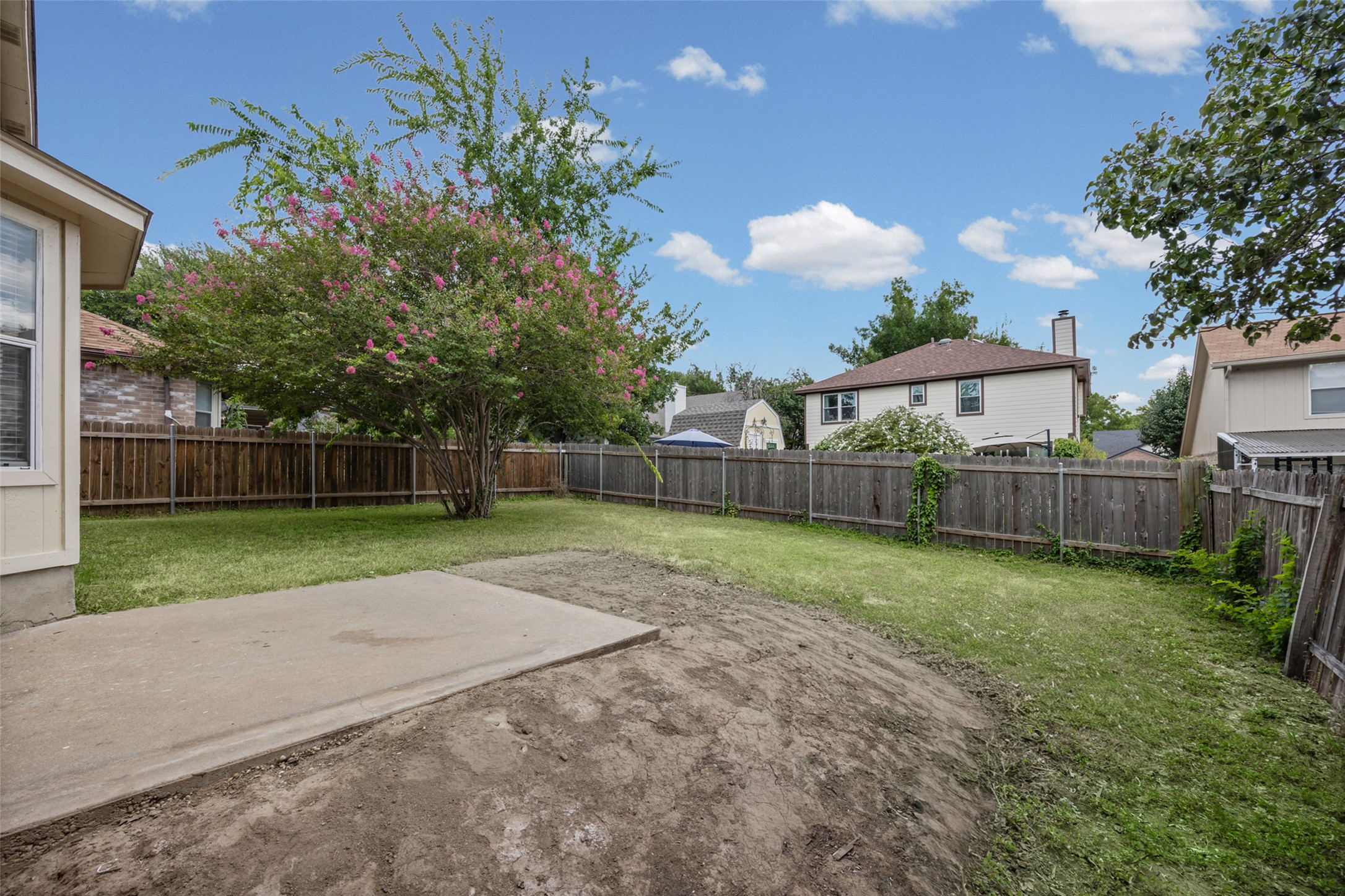 2432 Roundabout Lane Round Rock, TX 78664 - Photo 21 of 22 A spacious backyard awaits, ready for personalization with a blossoming crape myrtle tree and existing concrete patio.
