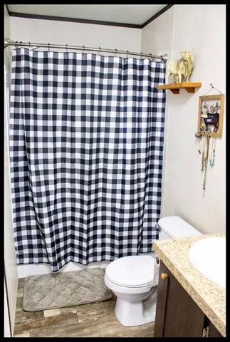 a bathroom with a toilet and a shower curtain