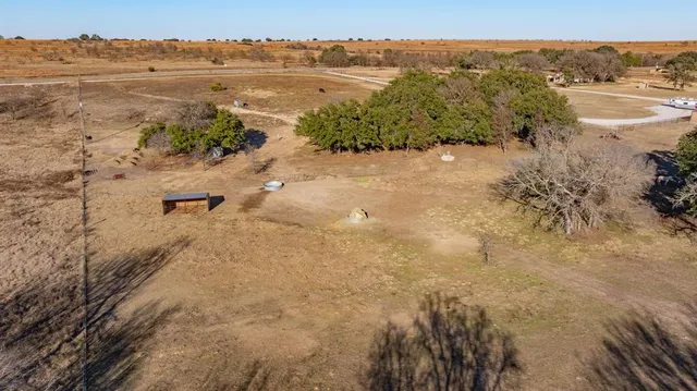 a view of a dry yard with wooden fence