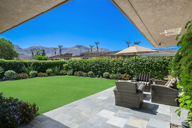 a view of a patio with a table and chairs under an umbrella