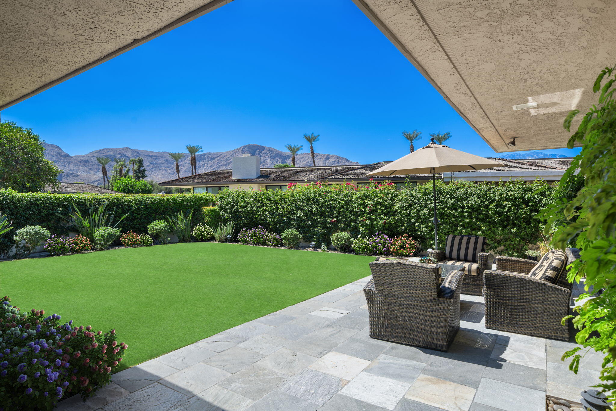6 Oxford Court Rancho Mirage, CA 92270 - Photo 20 of 42 a view of a patio with a table and chairs under an umbrella
