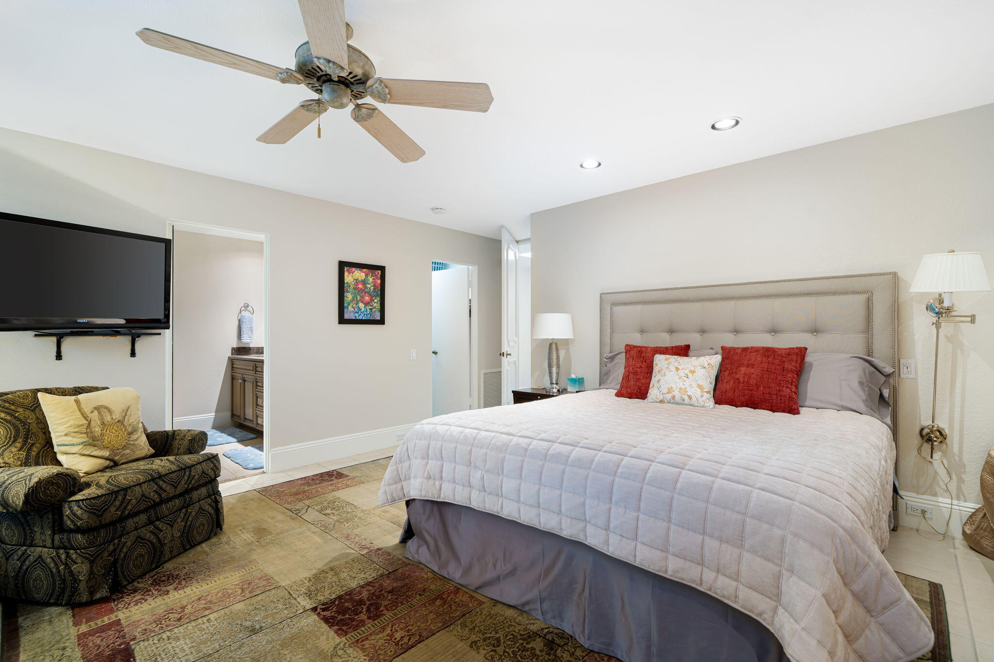 6 Oxford Court Rancho Mirage, CA 92270 - Photo 22 of 42 a bedroom with a bed a couch and a flat screen tv