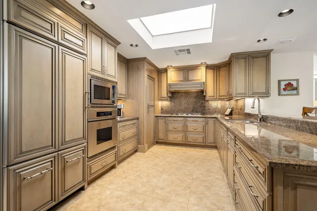 a kitchen with stainless steel appliances granite countertop a refrigerator sink and cabinets