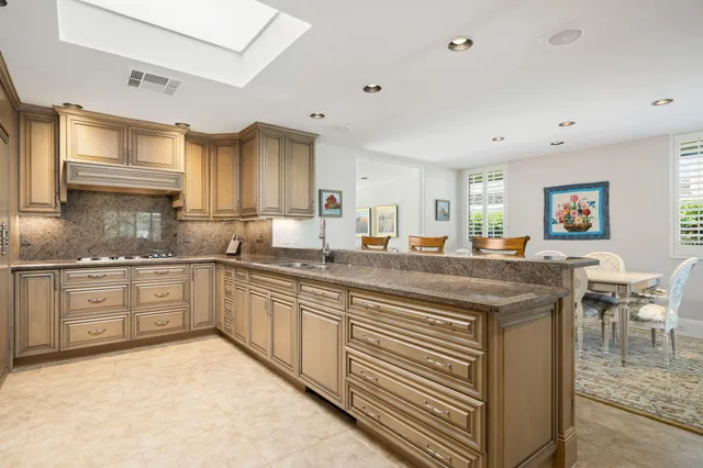 a kitchen with granite countertop a sink cabinets and stainless steel appliances