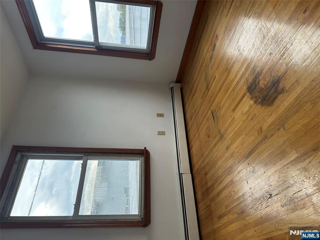 404 North 3rd Street, Unit 2 Harrison, NJ 07029 - Photo 3 of 9 a view of an empty room with wooden floor and a window