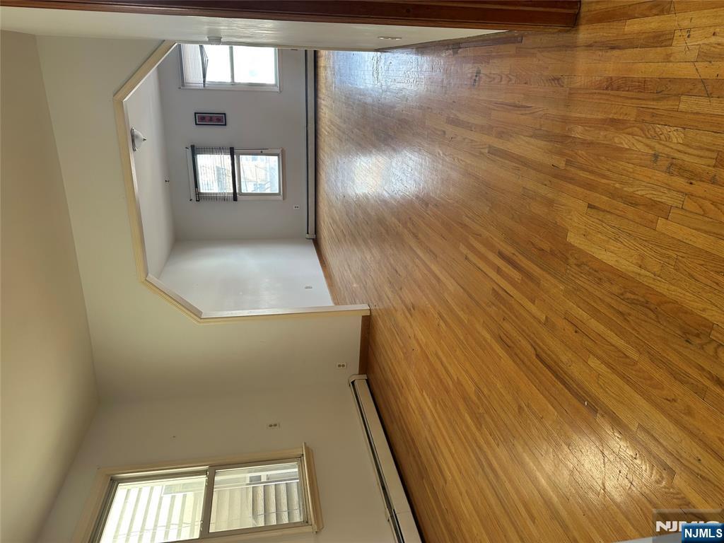 404 North 3rd Street, Unit 2 Harrison, NJ 07029 - Photo 7 of 9 a view of an empty room with wooden floor and a window