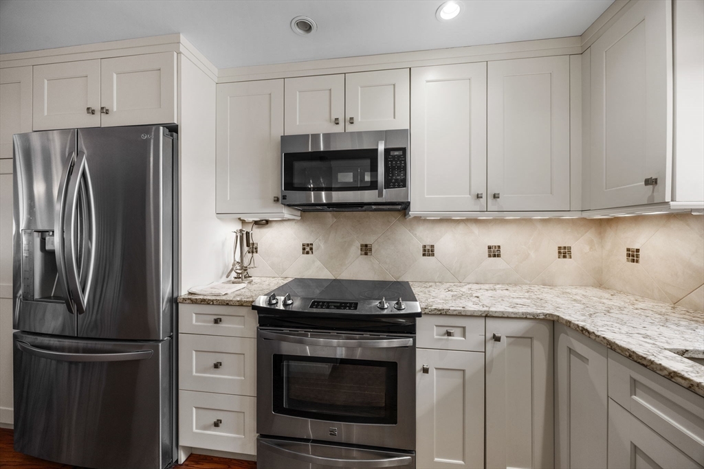 381 Great Oak Road, Unit 9 Mashpee, MA 02649 - Photo 5 of 42 a kitchen with cabinets stainless steel appliances and a sink