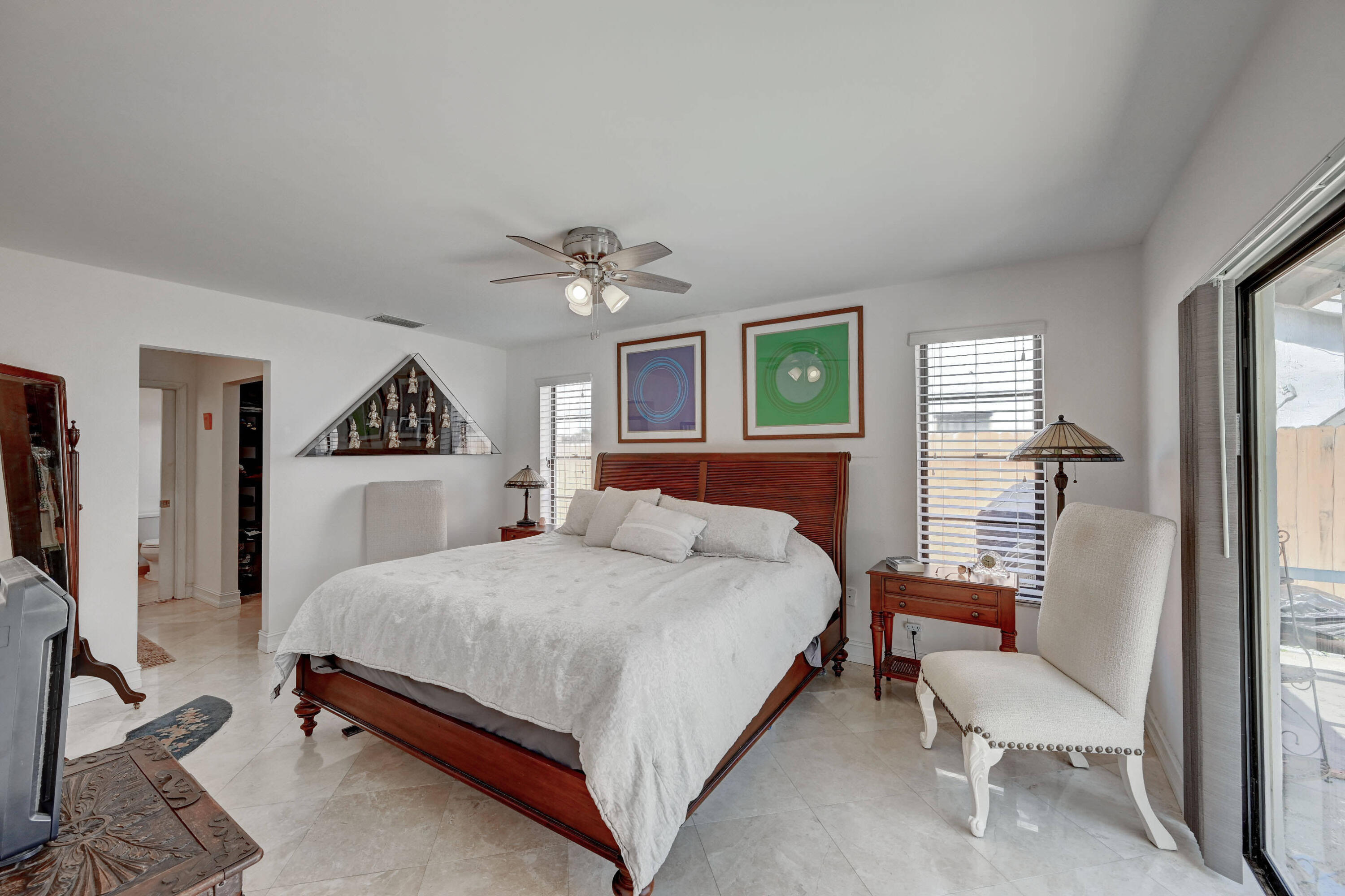 9682 Ohio Place Boca Raton, FL 33434 - Photo 17 of 37 a bedroom with a bed a chandelier and dresser