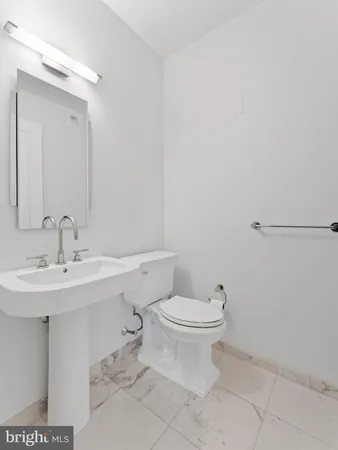 a bathroom with a sink a toilet and mirror