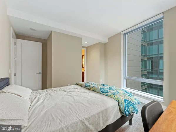 a bedroom with a bed and glass window