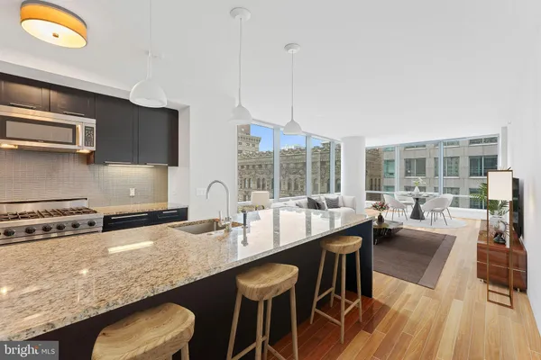 a kitchen with stainless steel appliances granite countertop a stove a sink a microwave and dining table