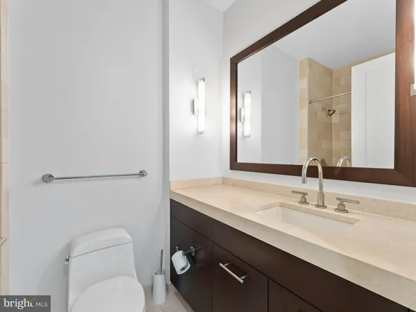 a bathroom with a toilet a sink a mirror and vanity