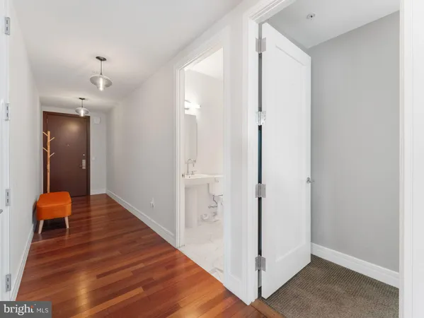 a hallway with wooden floor and closet