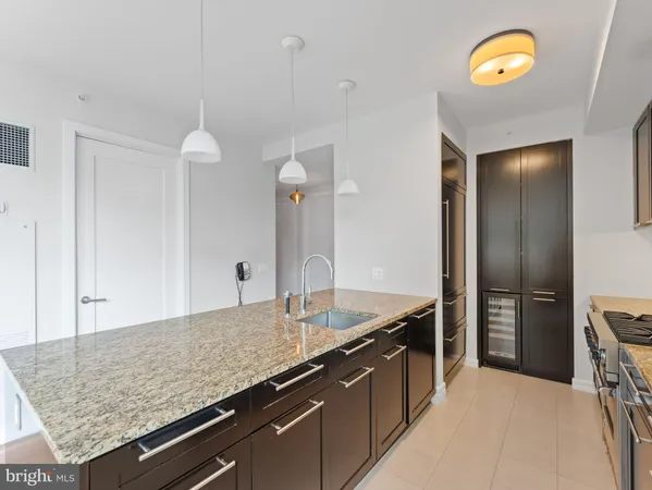 a kitchen with stainless steel appliances granite countertop a sink and a refrigerator