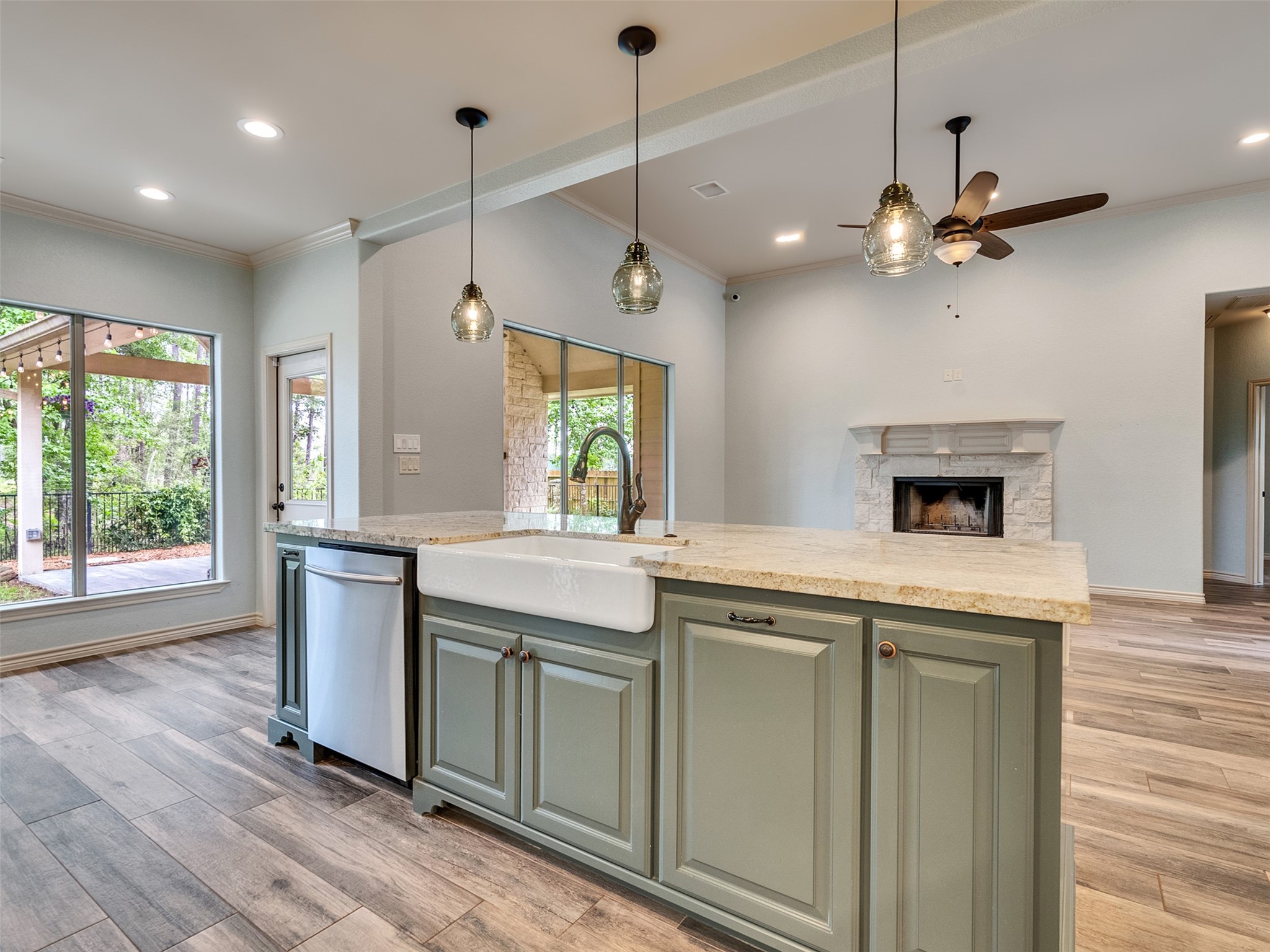 18005 Cindy Lane Conroe, TX 77302 - Photo 20 of 49 Kitchen flows into a spacious living area with a stone fireplace and ample natural light from large windows overlooking the backyard.