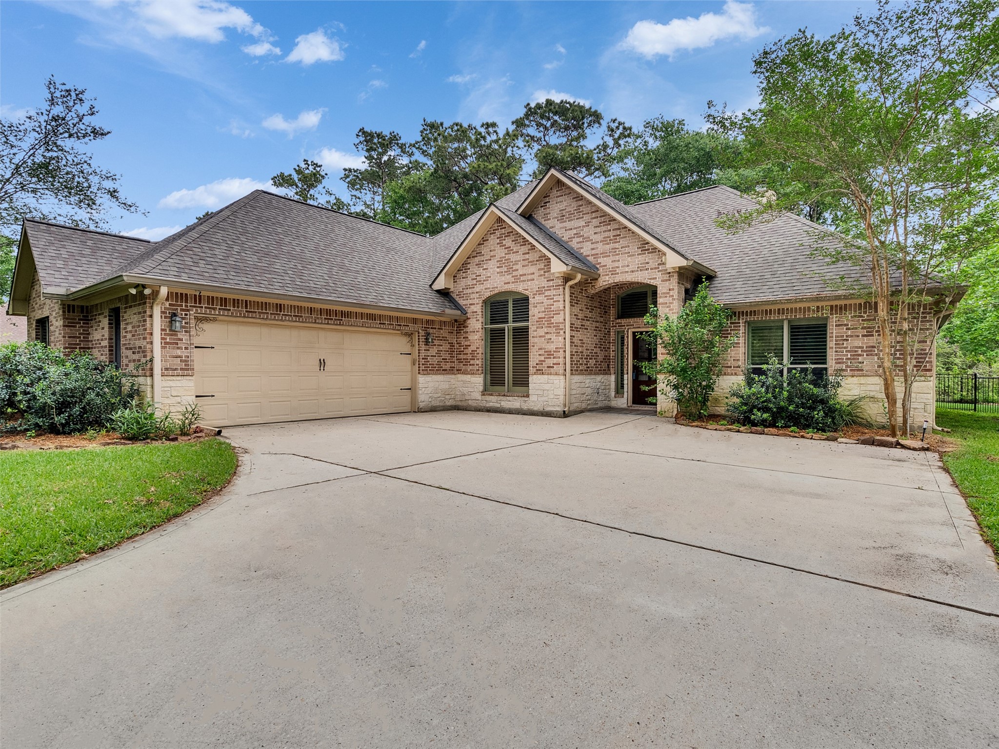18005 Cindy Lane Conroe, TX 77302 - Photo 2 of 49 This charming brick home features a spacious driveway leading to a two-car garage. Surrounded by lush greenery, the property offers a welcoming entrance with neatly maintained landscaping and a peaceful wooded backdrop.
