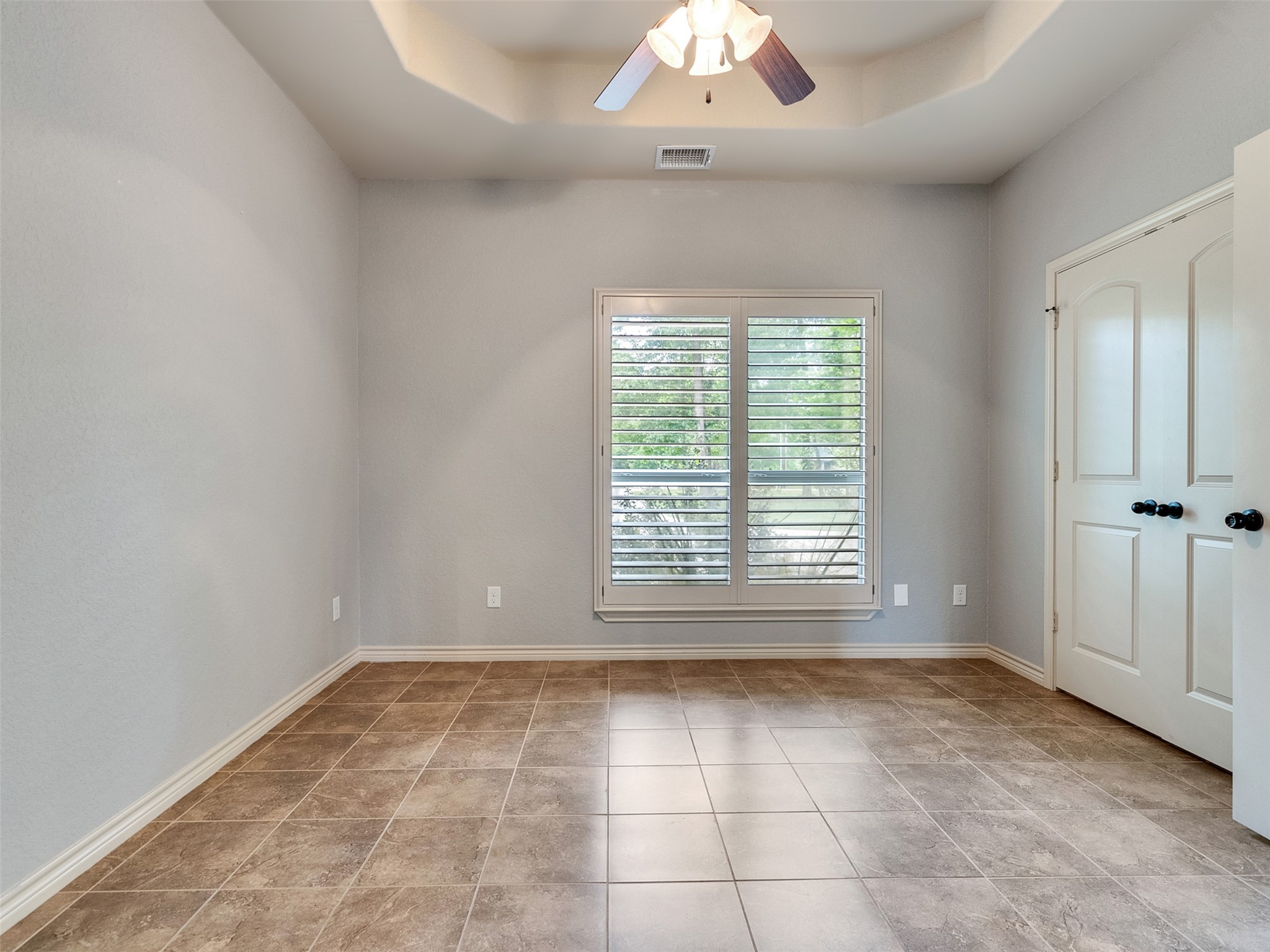 18005 Cindy Lane Conroe, TX 77302 - Photo 24 of 49 This room features neutral tones with tiled flooring and a ceiling fan. It has a large window with shutters, providing natural light, and a double-door closet.