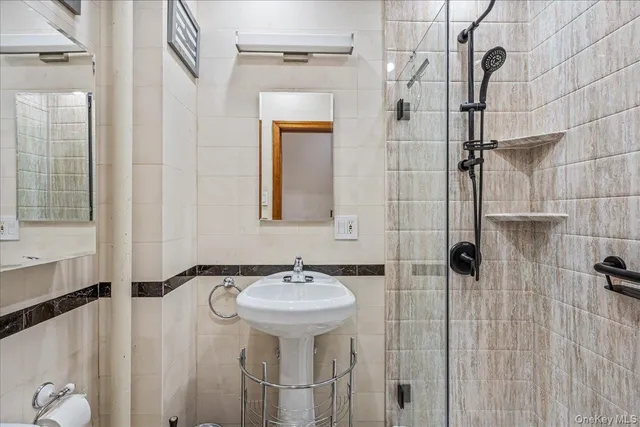 a bathroom with a sink mirror and shower