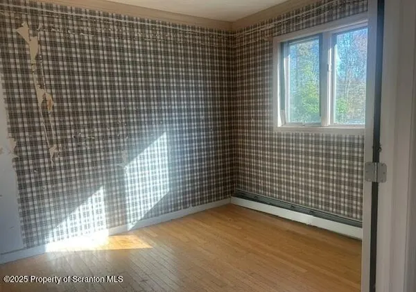 a view of a small space with wooden floor and a window