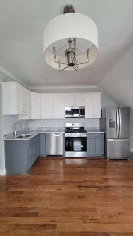 a kitchen with stainless steel appliances a large counter top a stove and cabinets