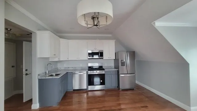 a kitchen with granite countertop a refrigerator and a stove top oven
