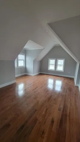 a view of empty room with wooden floor and windows