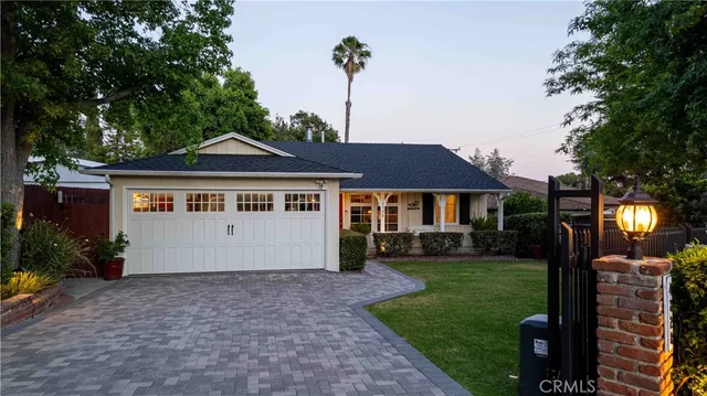 a front view of a house with a garden and plants