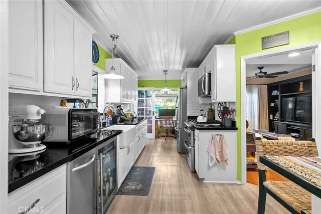 a kitchen with stainless steel appliances a stove a sink dishwasher and cabinets with wooden floor