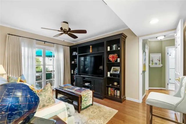 a living room with furniture a chandelier fan and a large window