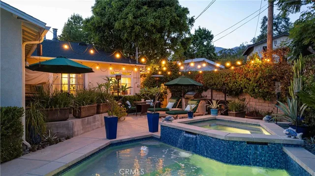 a view of a house with a yard and potted plants
