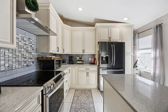 a kitchen with granite countertop a refrigerator stove and sink