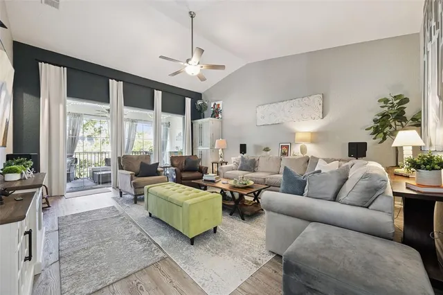 a living room with furniture kitchen view and a large window