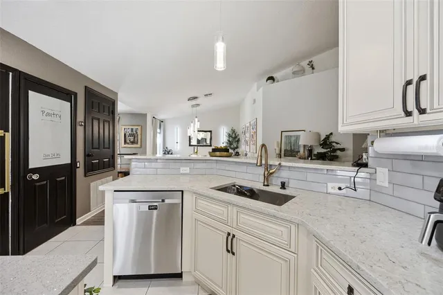 a kitchen with white cabinets and sink