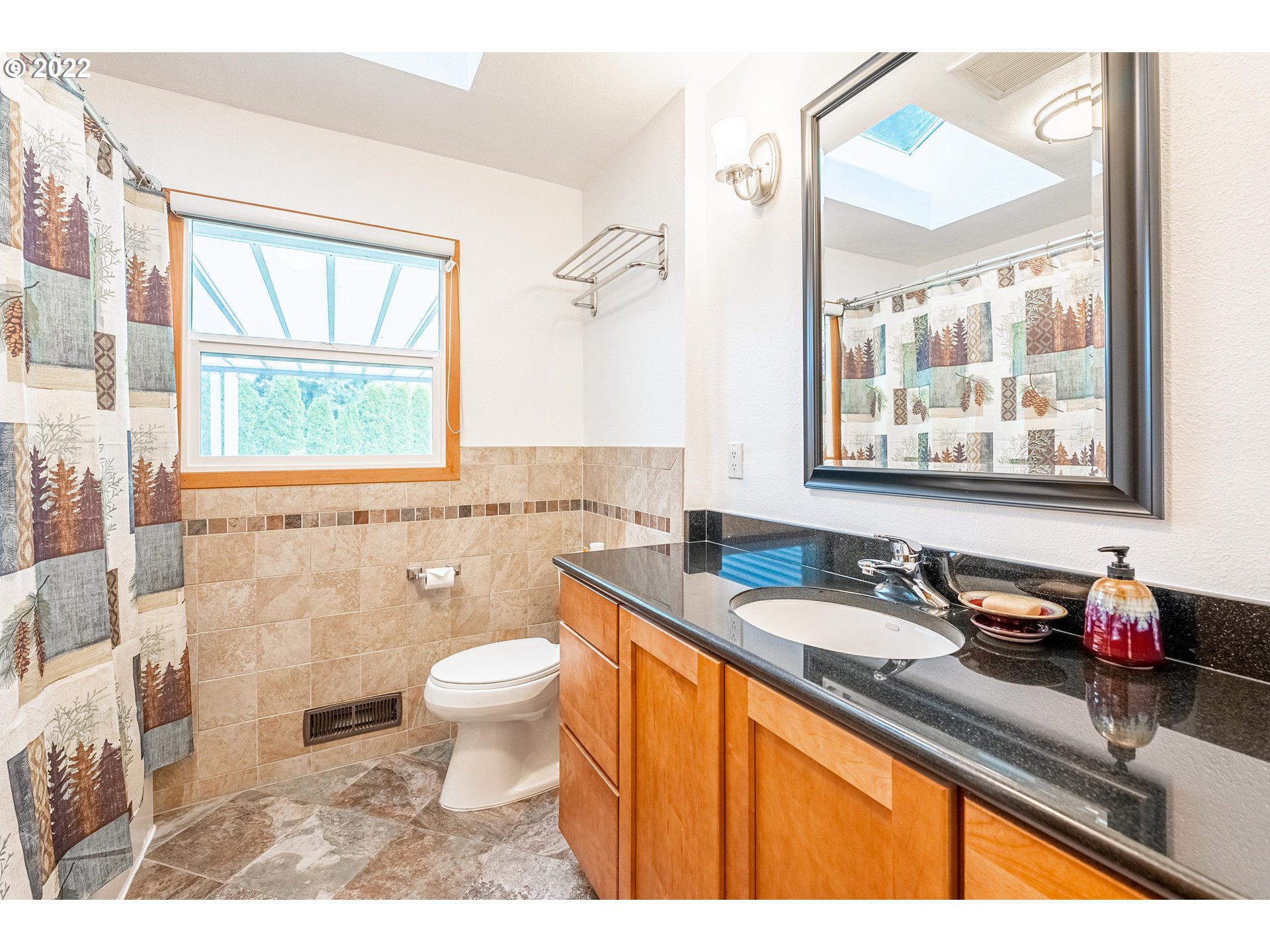 135 South Ridge Drive Portland, OR 97219 - Photo 14 of 32 a bathroom with a granite countertop sink a large mirror and a window