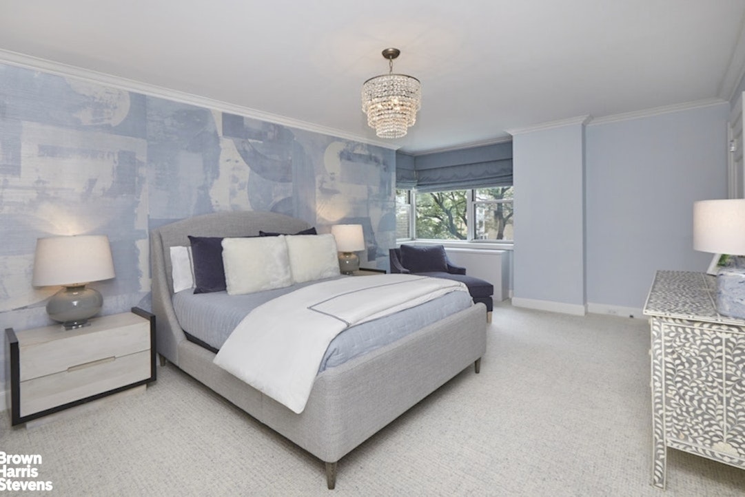 150 East 69th Street, Unit 4M Manhattan, NY 10021 - Photo 18 of 24 a bedroom with a bed and a lamp on table