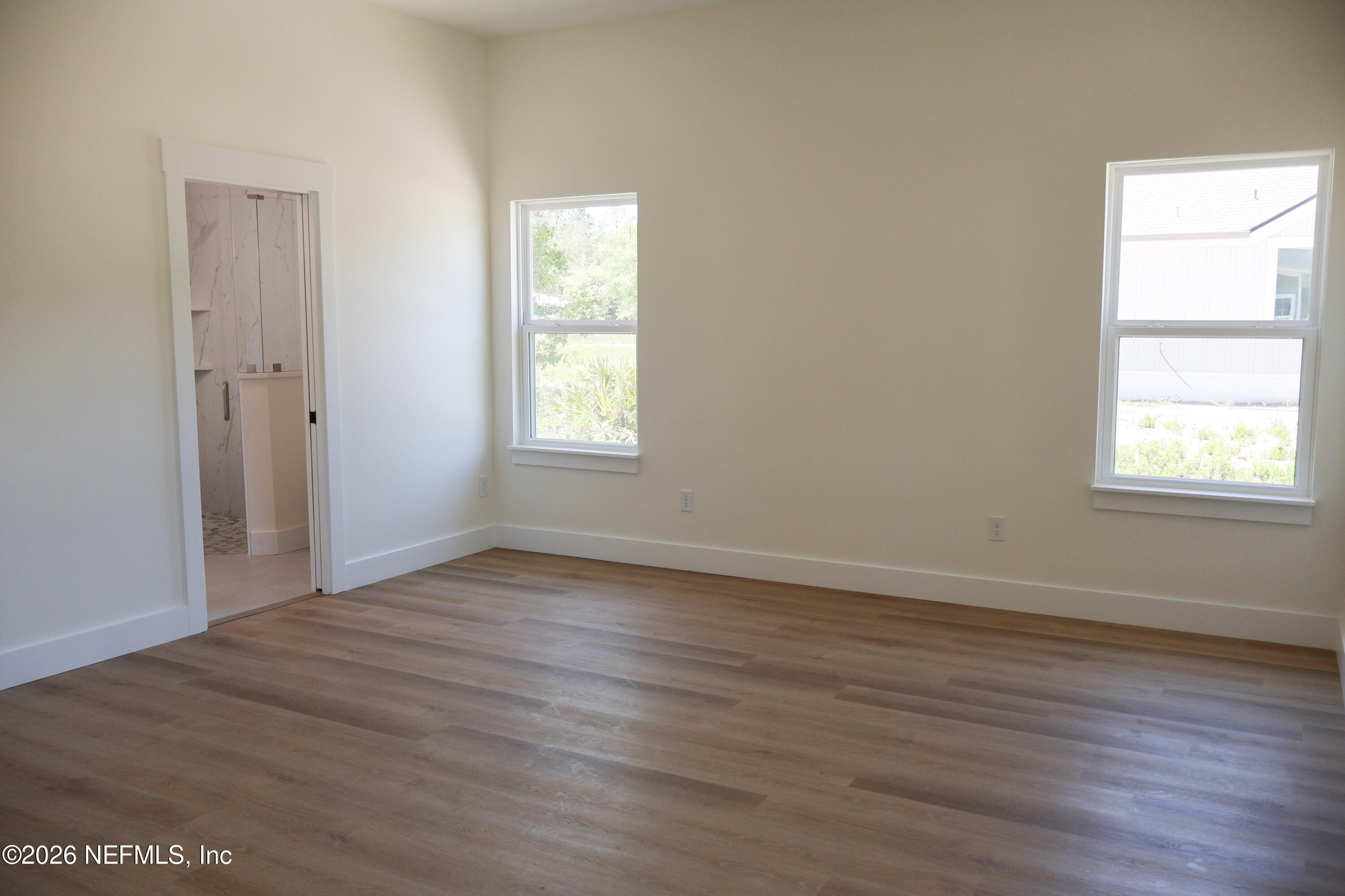 261121 Rowe Road Hilliard, FL 32046 - Photo 18 of 33 an empty room with wooden floor and windows
