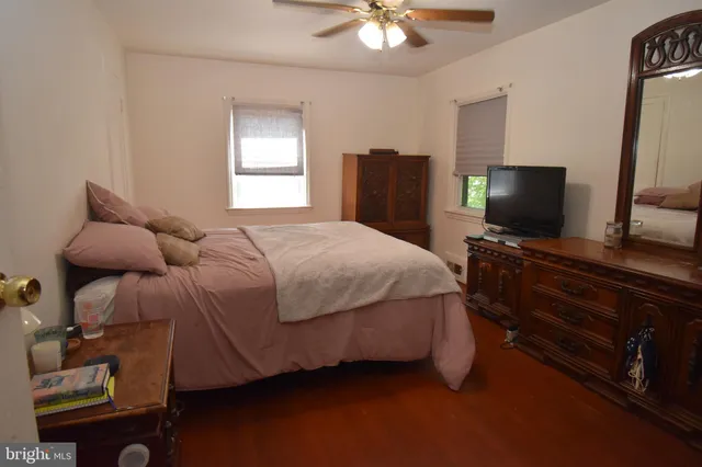 a bedroom with a bed and a flat tv screen on a dresser