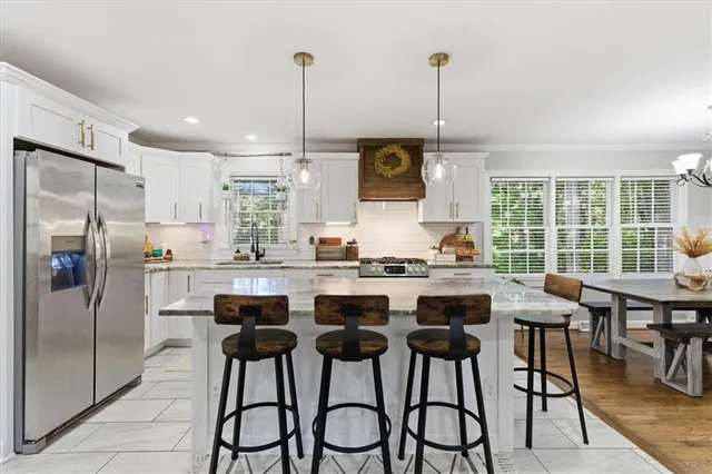 a kitchen with stainless steel appliances kitchen island a table and chairs in it