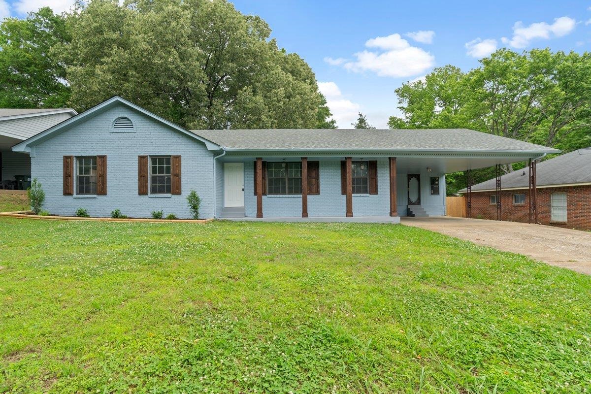 6410 Coteswood Road Memphis, TN 38134 - Photo 1 of 25 Ranch-style home with concrete driveway, brick siding, an attached carport, and a front yard