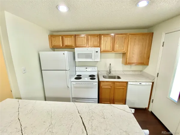 a kitchen with a refrigerator a stove top oven a sink and dishwasher