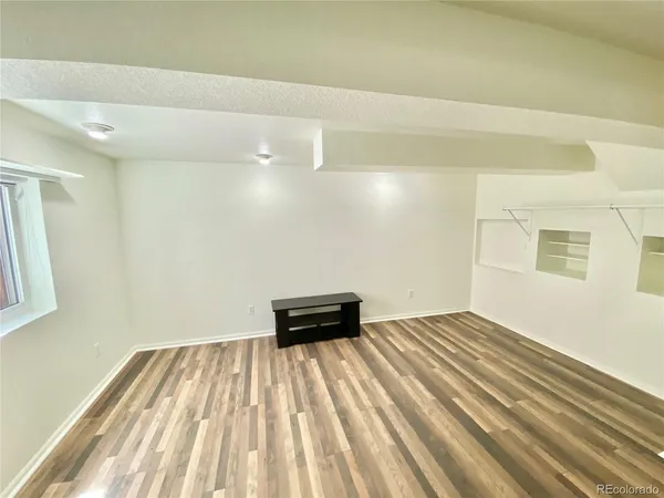 a view of a room with wooden floor and white walls