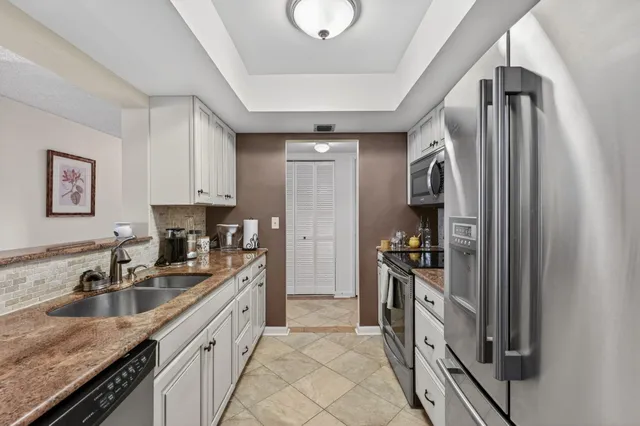 a kitchen with a sink refrigerator and cabinets